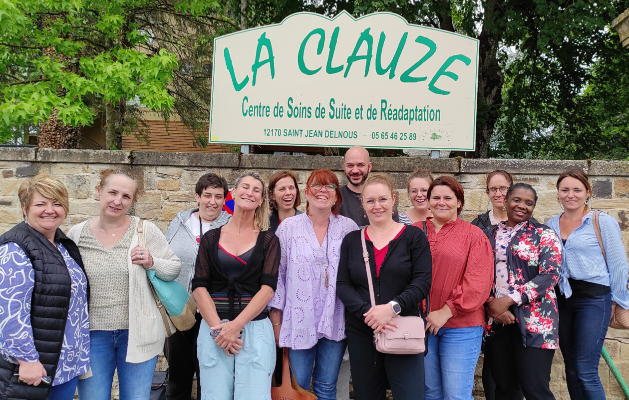 Collaborateurs souriants prennent la pose devant un établissement avant leur visite.