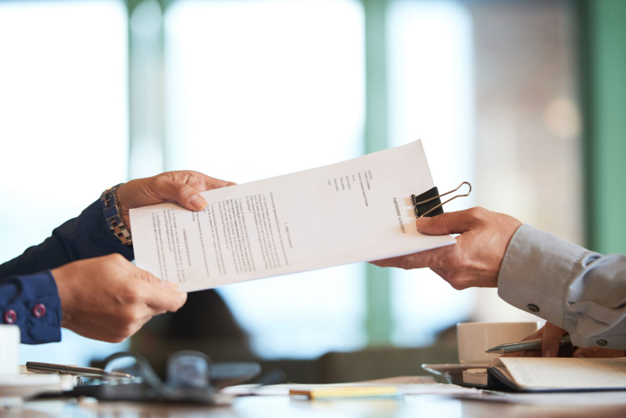 Deux personnes se faisant passer un contrat.