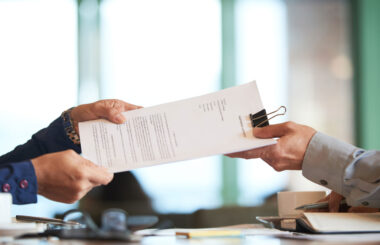 Deux personnes se faisant passer un contrat.